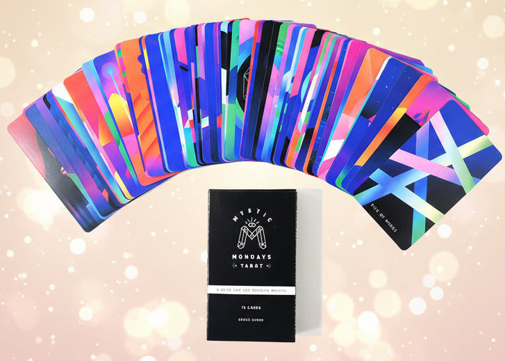 Colorful deck of cards fanned out with a black box labeled 'Mystic Mondays Tarot' on a white background.