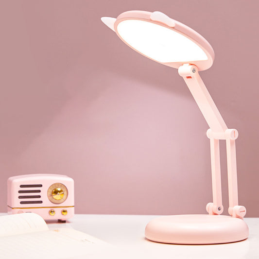 Pink desk lamp on a white surface with a pink background
