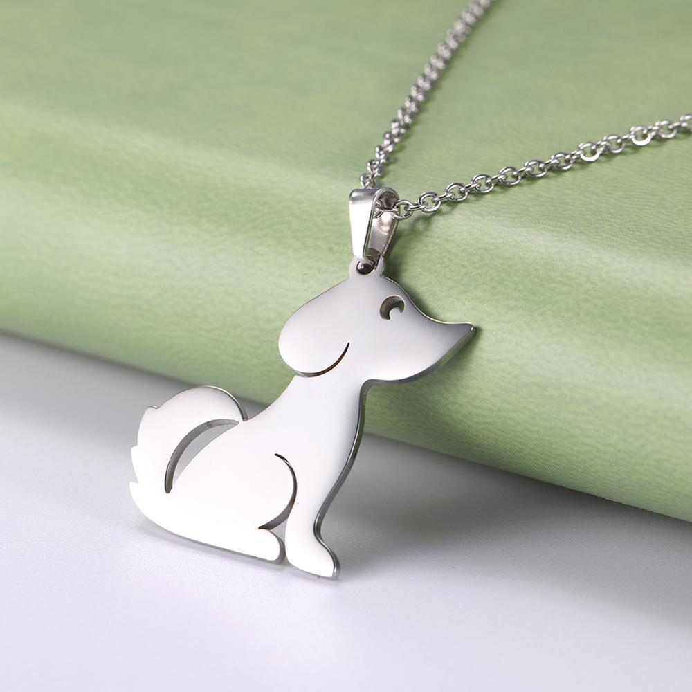Silver dog-shaped pendant on a chain against a green and white background