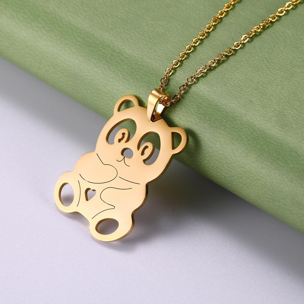 Gold panda bear pendant on a chain against a green and gray background