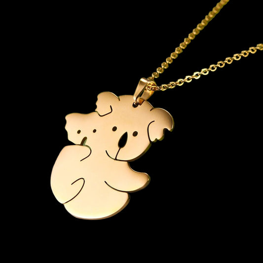 Gold koala pendant necklace on a green and gray background