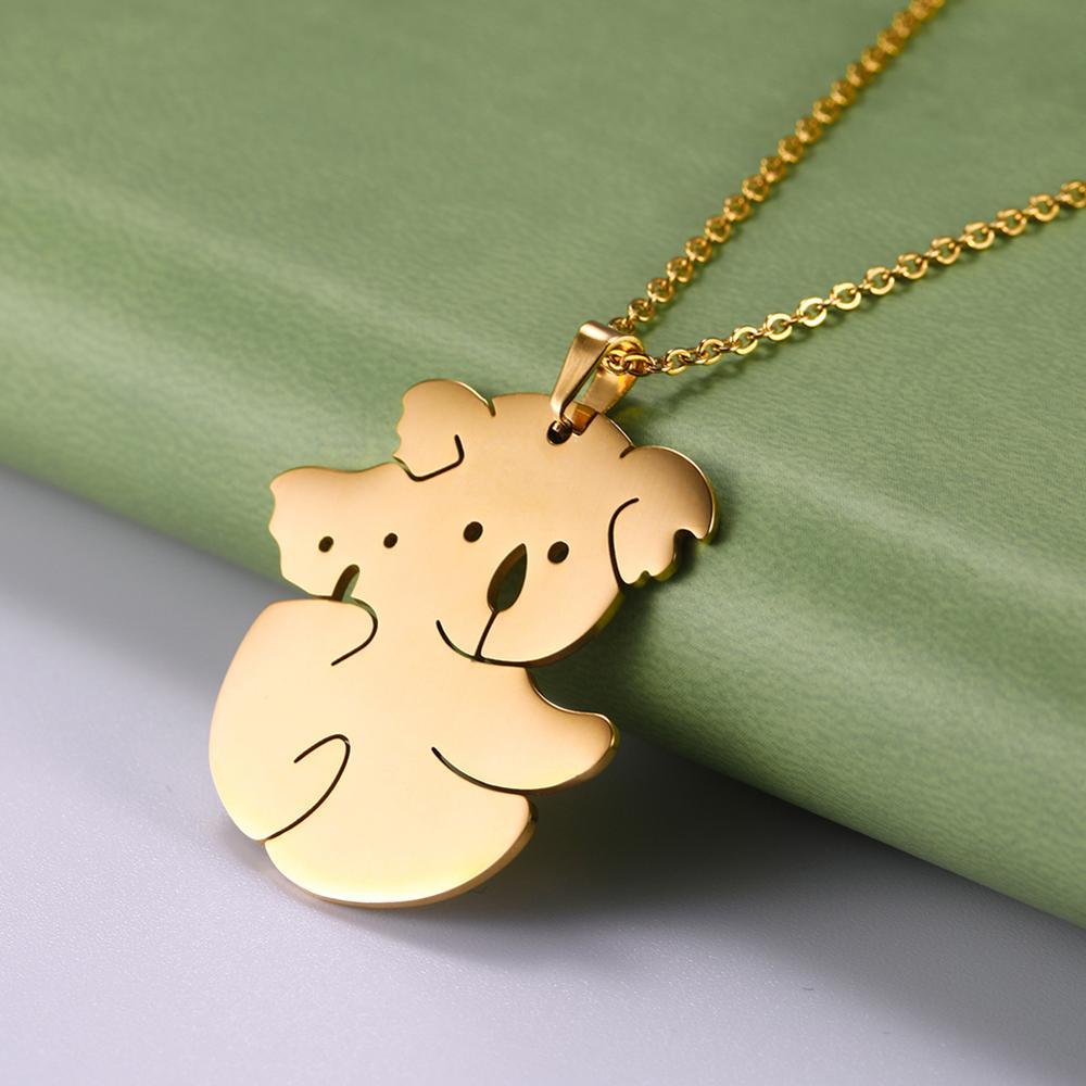 Gold koala pendant necklace on a green and gray background