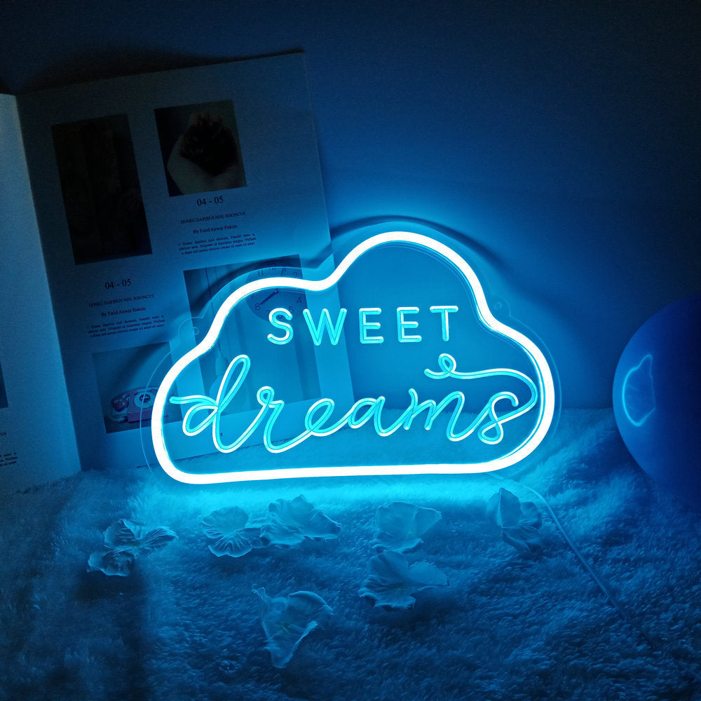 Neon sign shaped like a cloud with 'Sweet dreams' text on a soft surface.