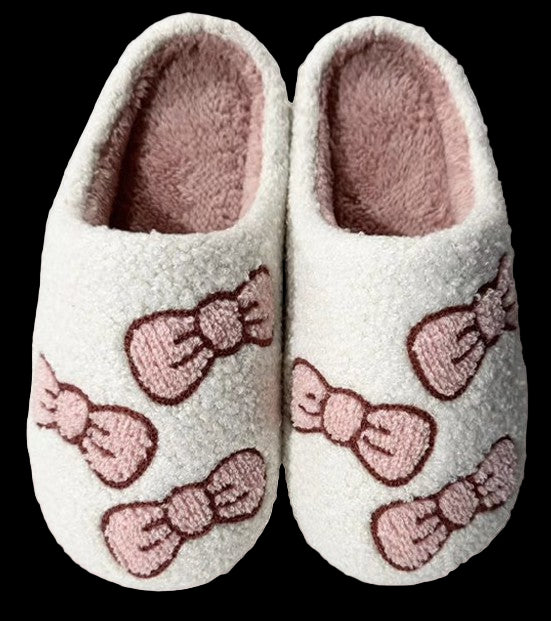 Pair of slippers with pink bows on a light pink background