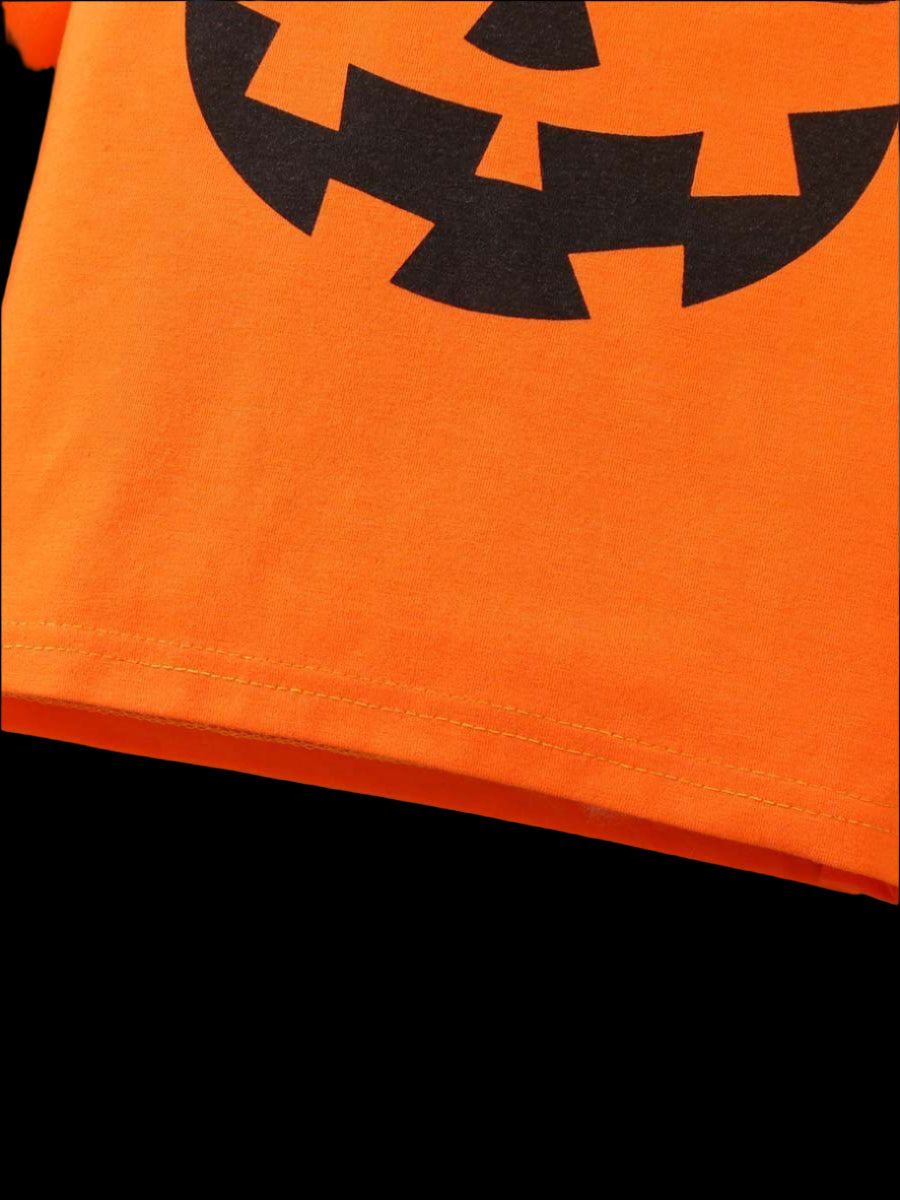 Orange fabric with a black jack-o'-lantern face design on a blue background