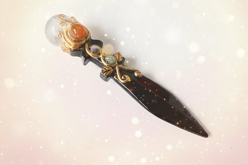 Decorative dagger with ornate handle on a white surface
