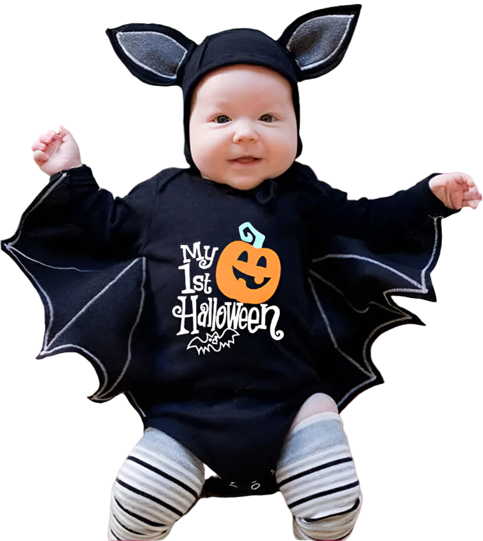 Baby wearing a Halloween-themed outfit with bat wings and a pumpkin design on a textured surface.