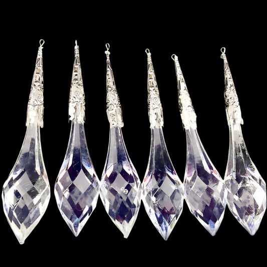 Set of six clear crystal teardrop pendants on a dark background