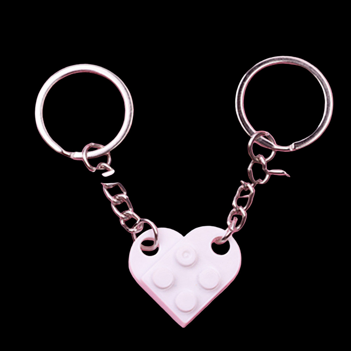 Heart-shaped keychain with a pink chain on a pink background