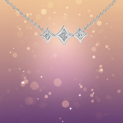 Silver necklace with three diamond-like pendants on a white background