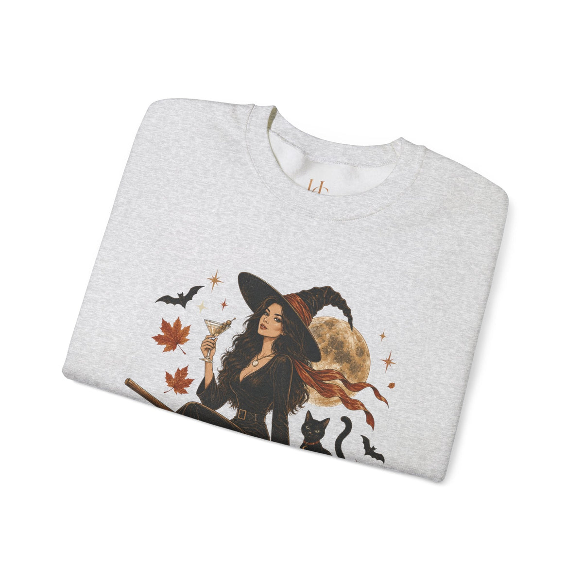 A light heather gray crewneck sweatshirt featuring a graphic print of a witch in a black hat and dress, holding a glass, surrounded by black cats, bats, autumn leaves, and a full moon.