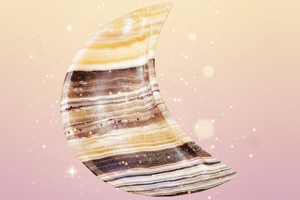 Half-moon shaped stone with striped pattern on a dark surface