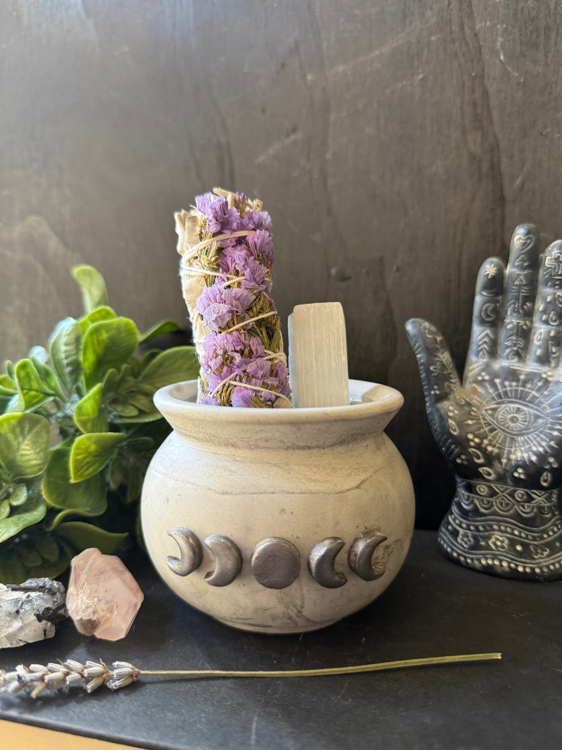 Decorative stone pestle and mortar with herbs on a dark surface