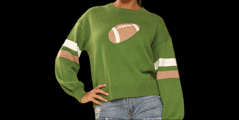 Woman wearing a green sweatshirt with a football design, denim shorts, and white sneakers on a beige background