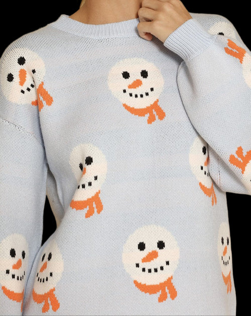 Light blue sweater with snowman patterns worn by a person against a beige background