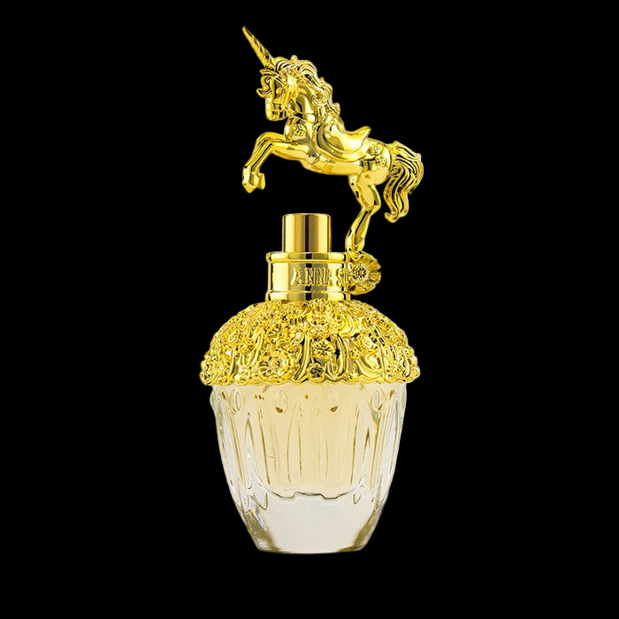 Gold and clear perfume bottle with unicorn on top against a white background