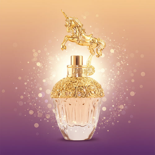Gold and clear perfume bottle with unicorn on top against a white background