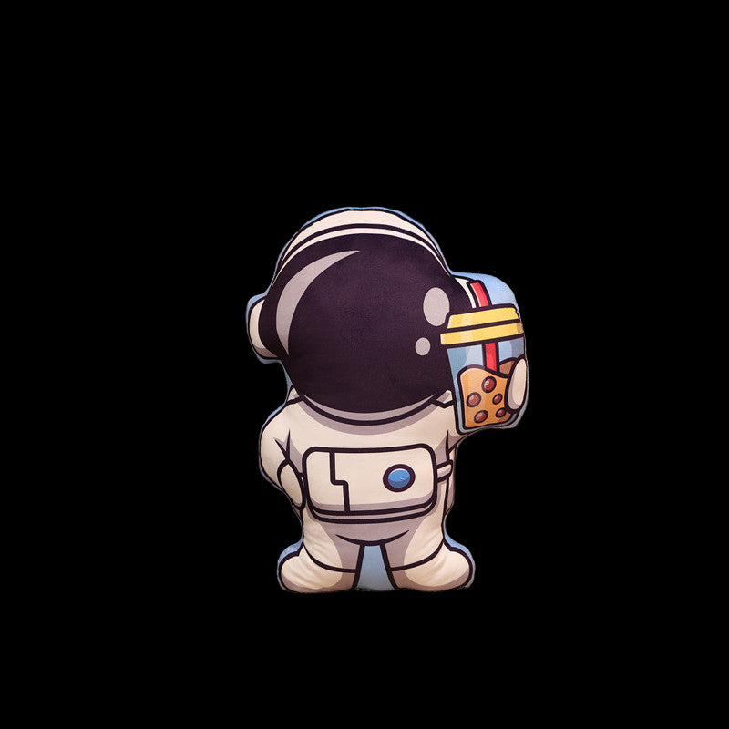 Cushion shaped like an astronaut on a couch with a plant and small model ship in the background