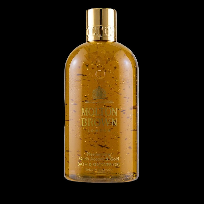 Bottle of Molton Brown bath and shower gel with gold cap on a white background