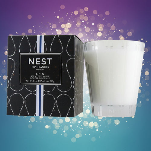 White candle next to its packaging with 'NEST Fragrances' branding on a white background