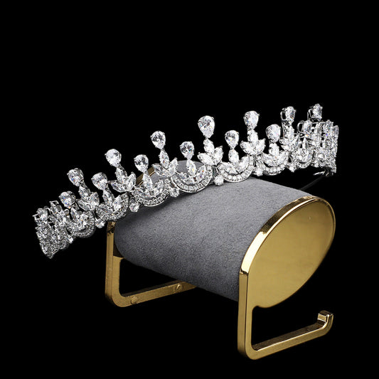 Diamanté tiara on a gold and gray stand against a black background