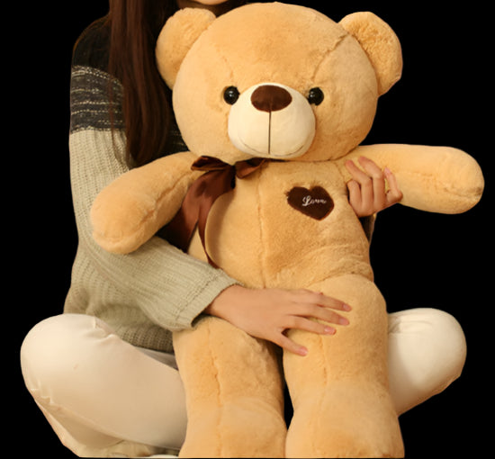 Woman holding a large teddy bear in a cozy indoor setting