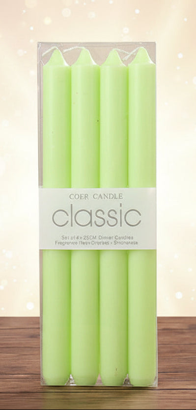 Pack of green candles in clear packaging on a wooden surface with a blurred background