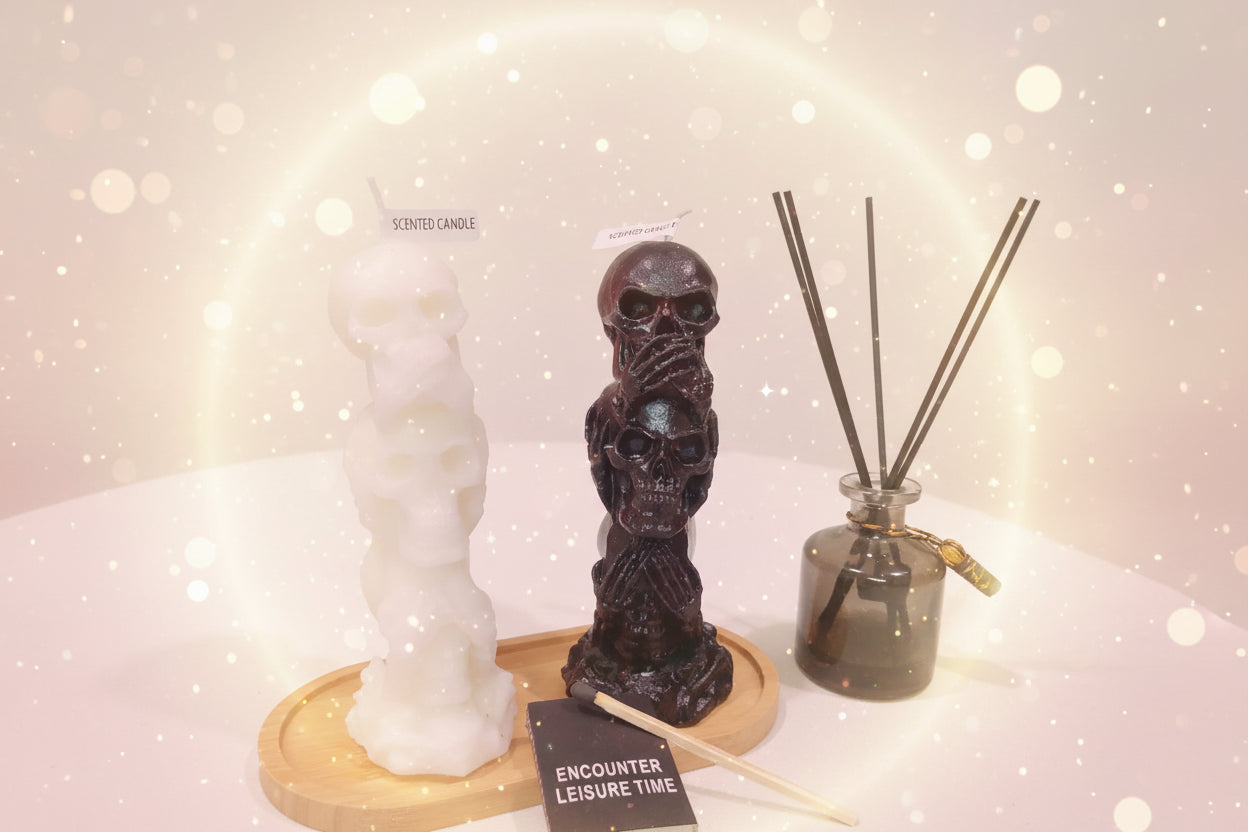 Two skull-shaped candles on a wooden stand with a diffuser bottle in the background.