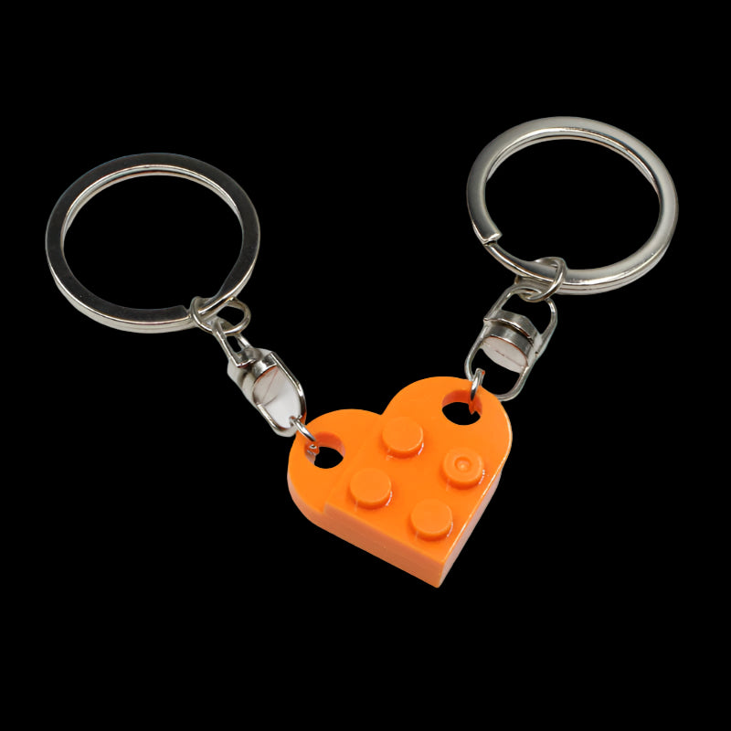 Two keychains with heart-shaped orange Lego piece pendants on a white background