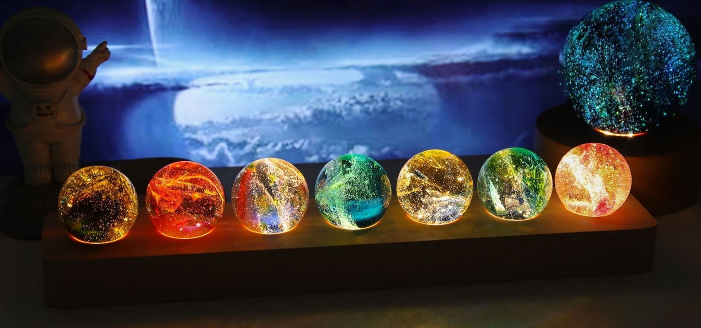 Colorful glass beads resembling stars on a dark background with an astronaut figure.