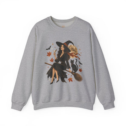 A heather gray crewneck sweatshirt featuring a large graphic print of a witch riding a broomstick with a black cat, surrounded by autumn leaves and bats.