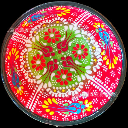 Colorful decorative plate with floral patterns on a textured surface