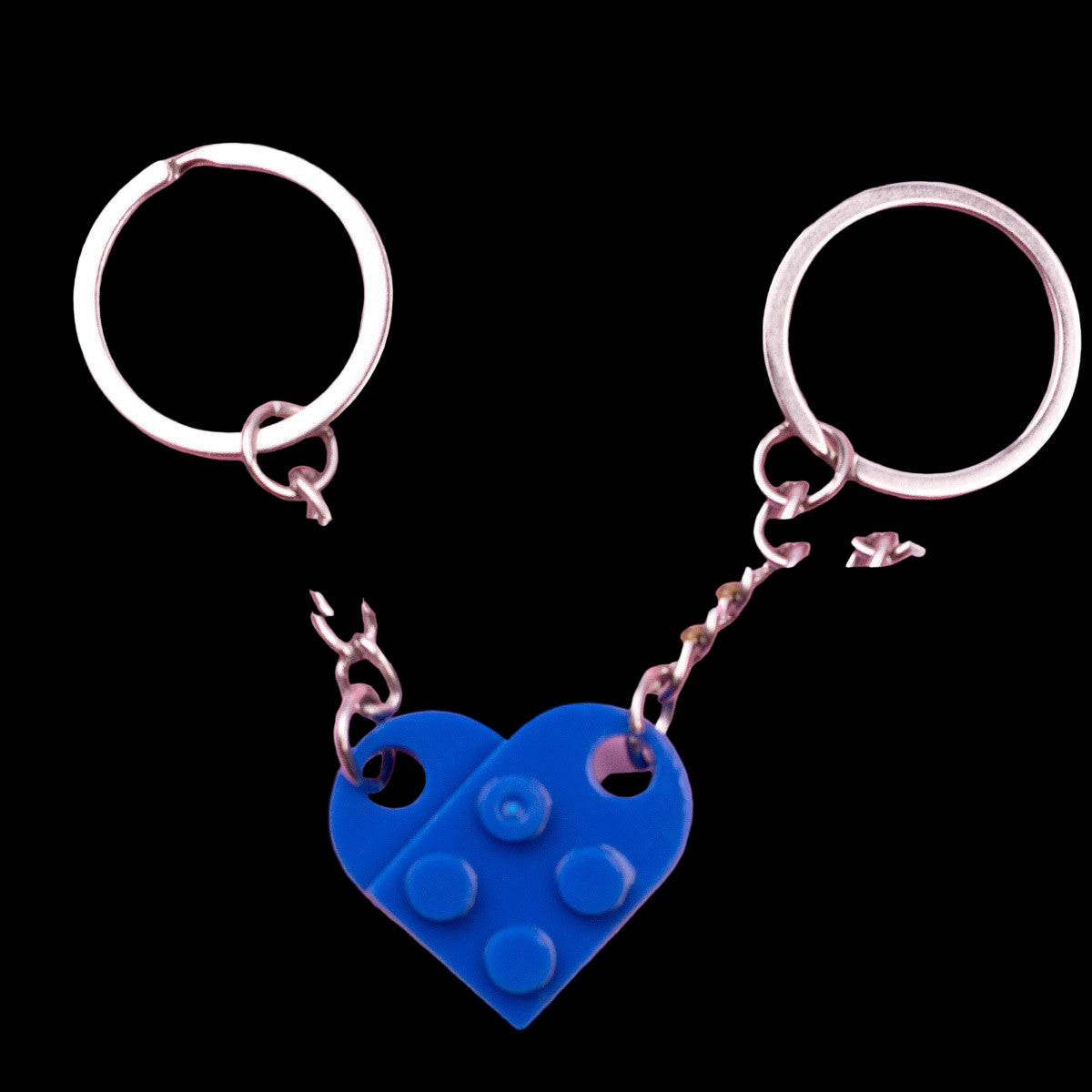 Keychain with blue heart-shaped LEGO piece charm on a pink background