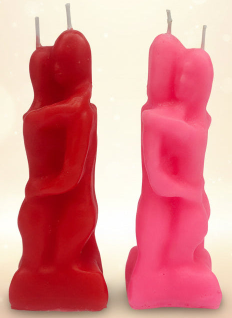 Two abstract candle sculptures, one red and one pink, on a light gray background.