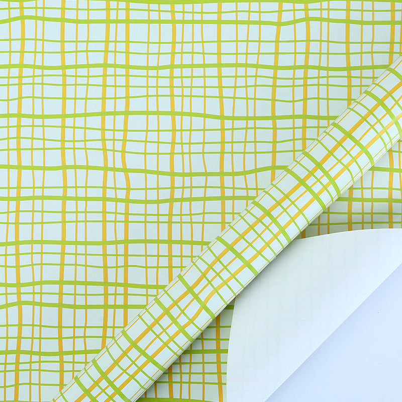 Roll of paper with green and yellow grid pattern on a white background