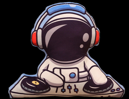 Cushion shaped like an astronaut sitting on a couch with a plant and wooden cabinet in the background.