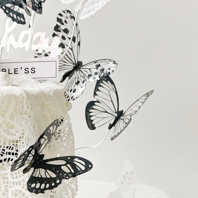 Black and white butterfly decorations on a textured surface with a blurred background.