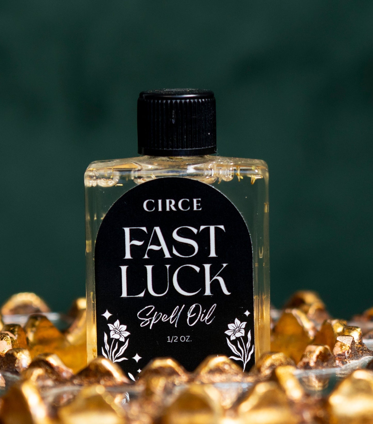 Bottle of Circe Fast Luck Spell Oil surrounded by gold coins on a dark background