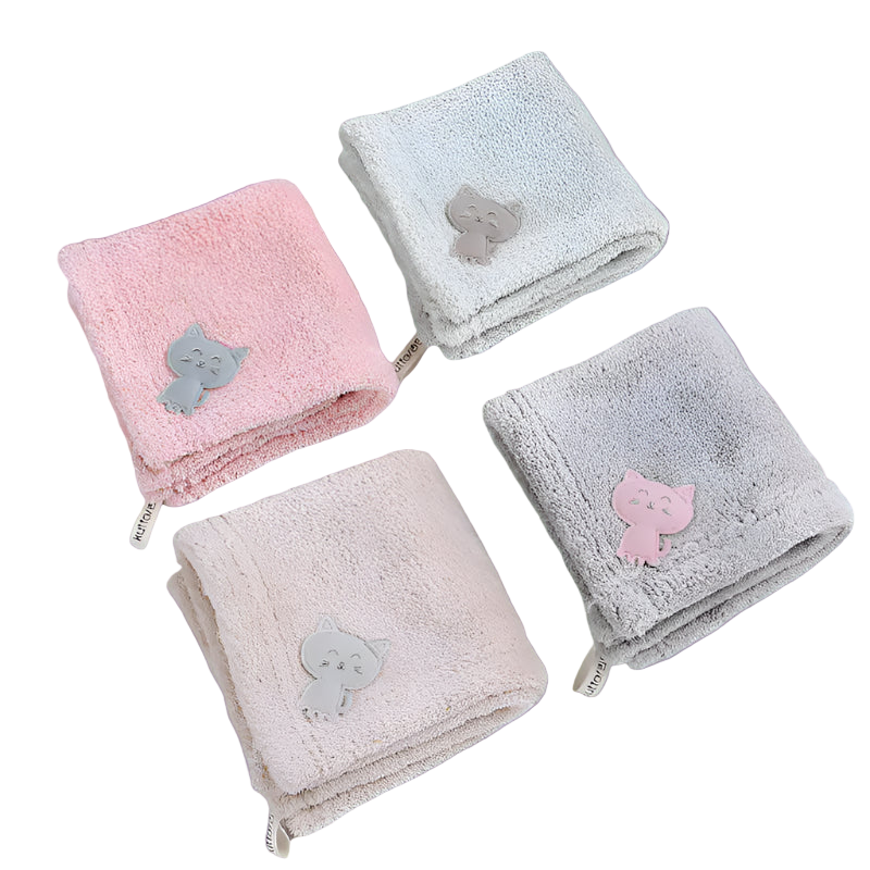Four folded towels with cat appliqués on a white background