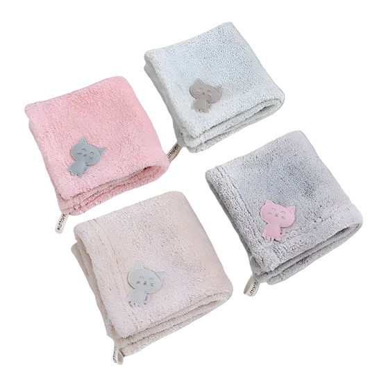Four folded towels with cat appliqués on a white background