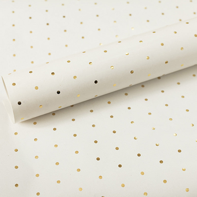 Roll of white paper with gold polka dots