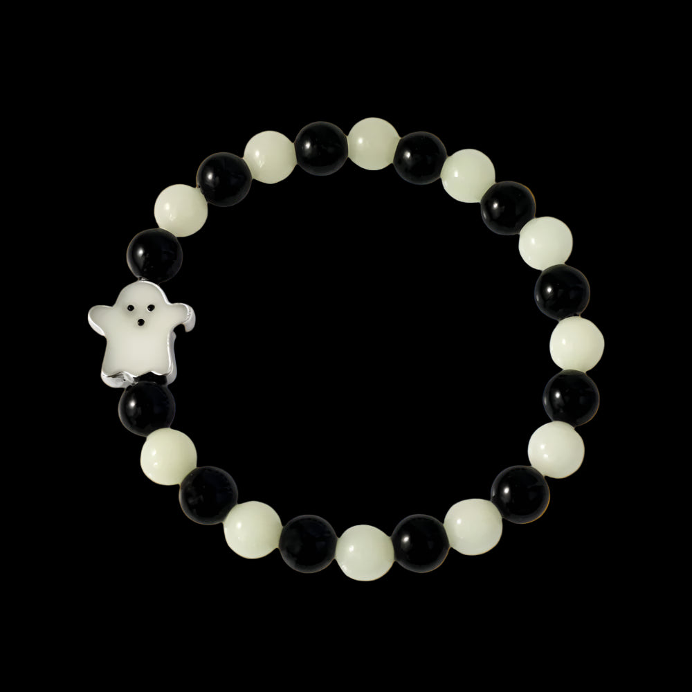 Beaded bracelet with black and white beads and a ghost charm on a white background
