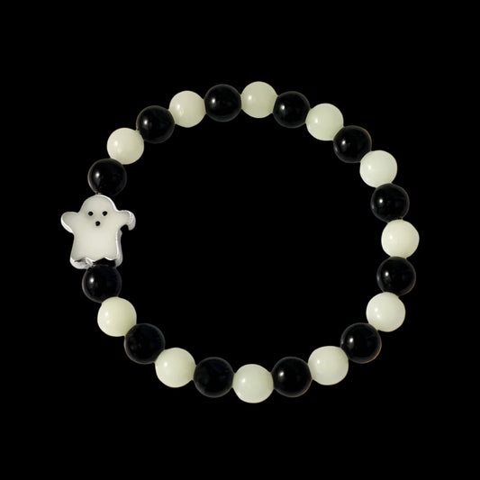 Beaded bracelet with black and white beads and a ghost charm on a white background