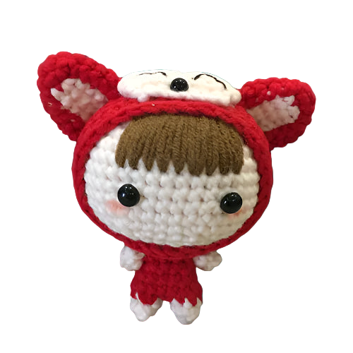 Small crochet doll with red hood and white face on a textured surface