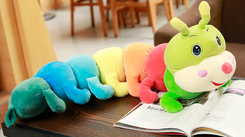 Colorful caterpillar plush toy on an open book in a restaurant setting