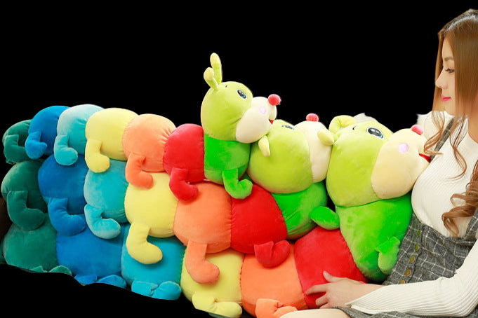 Woman sitting on a couch with colorful caterpillar-shaped cushions.