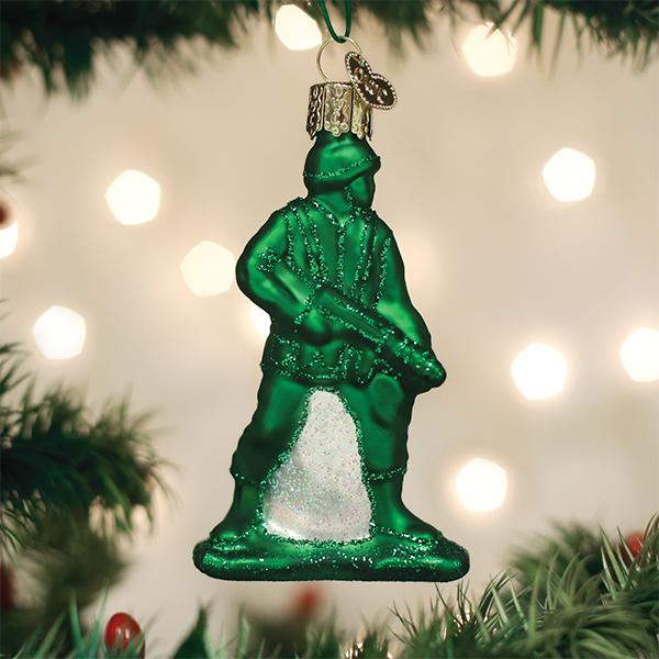 Green glass soldier ornament on a Christmas tree with blurred lights in the background