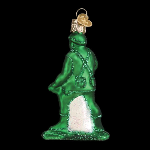 Green glass ornament of a standing figure on a white background