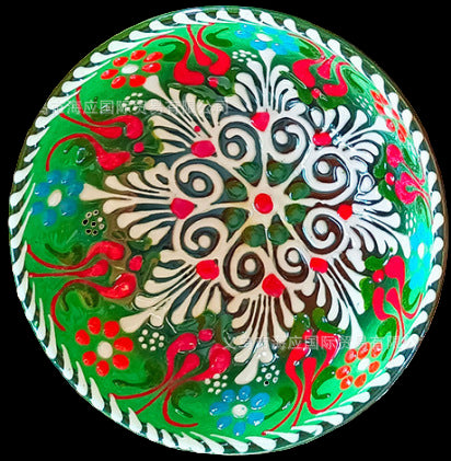 Decorative plate with intricate patterns on a textured fabric background