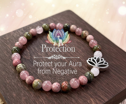 Glowing crystal bracelet with a wooden plaque featuring text and lotus designs on a wooden surface.